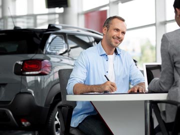 Ein Mann unterzeichnet den Kaufvertrag beim Autoankauf Ravensberg